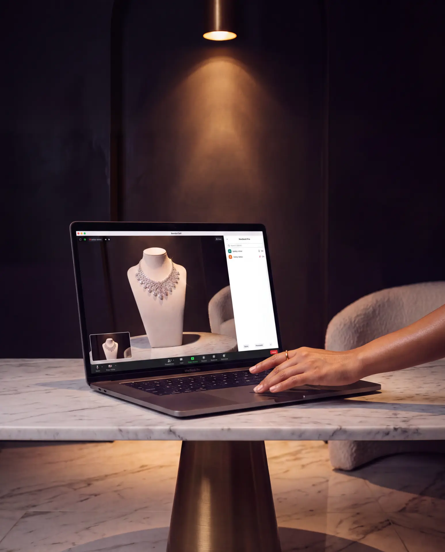 A crafted diamond necklace shown on a laptop video call at a marble table